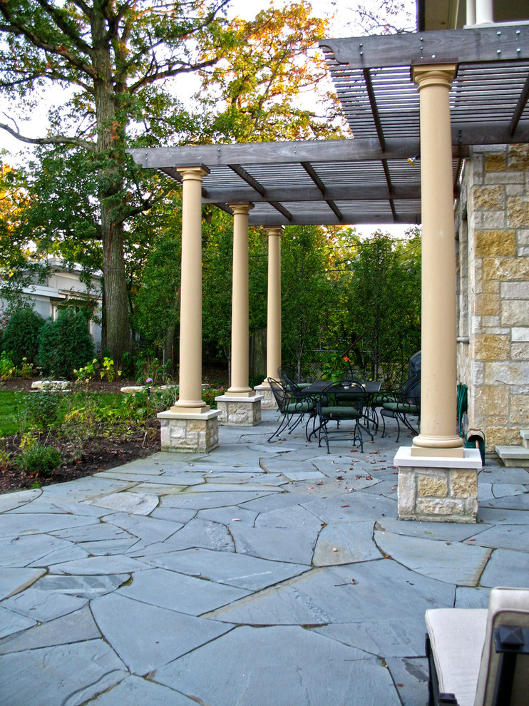 Inspiration for a timeless backyard stone patio remodel in Chicago with a pergola