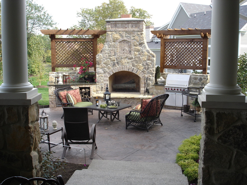 Esempio di un ampio patio o portico stile rurale dietro casa con cemento stampato e una pergola