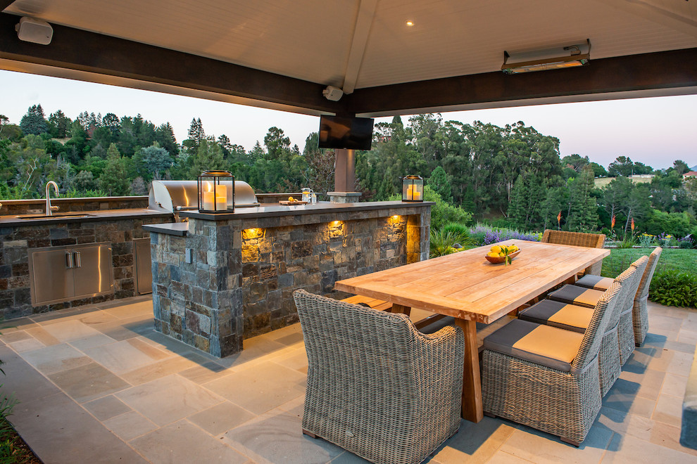 Inspiration pour une grande terrasse arrière traditionnelle avec une cuisine d'été, des pavés en pierre naturelle et un gazebo ou pavillon.