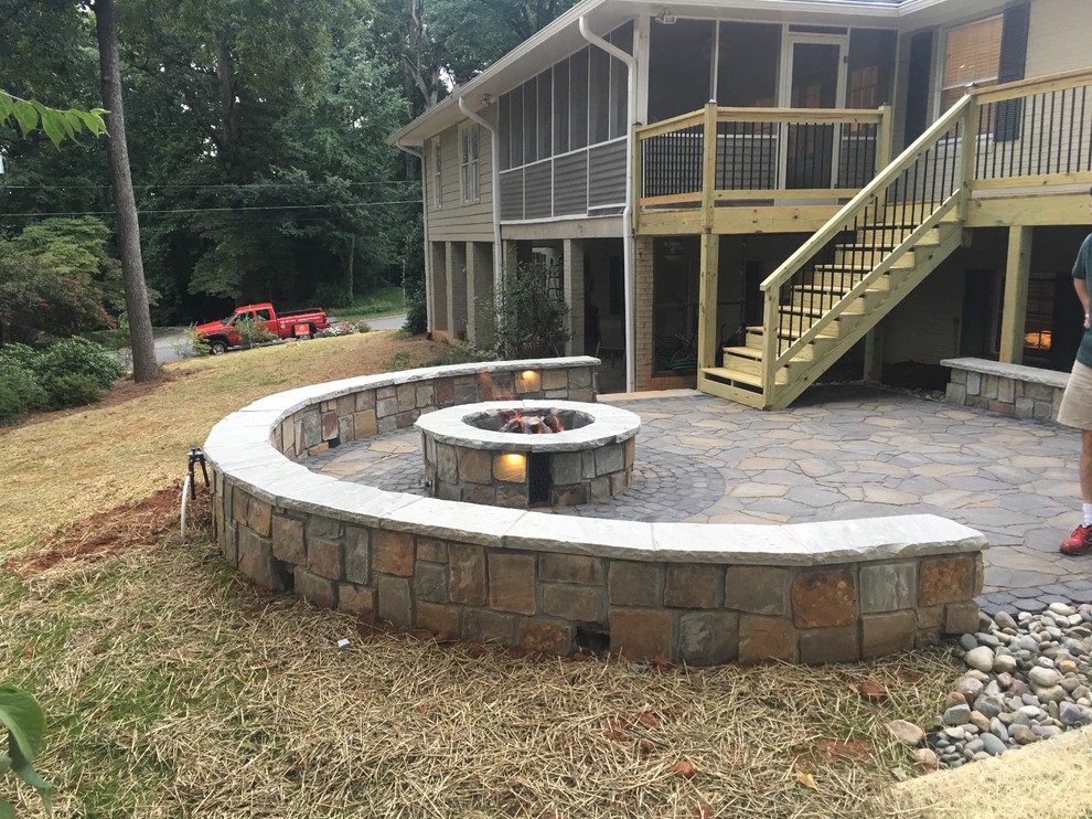 This is an example of a medium sized rustic back patio in Other with a fire feature and natural stone paving.