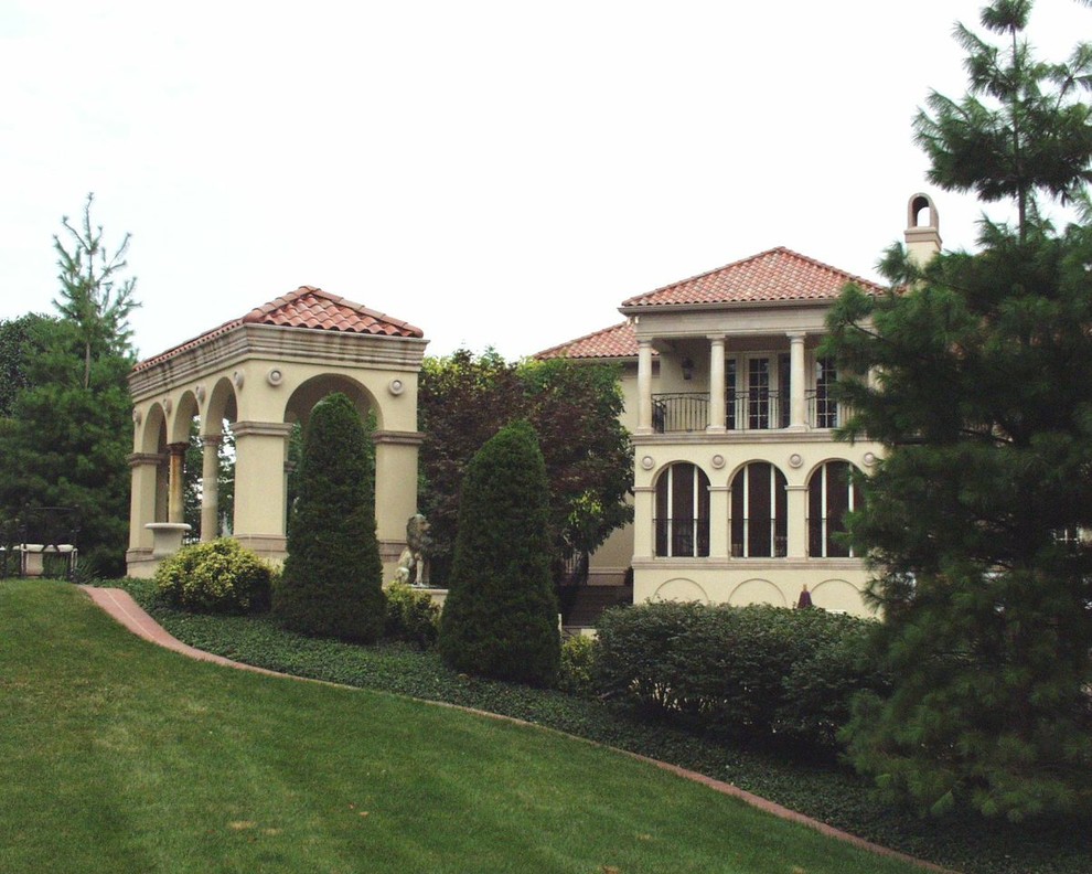 Exempel på en stor medelhavsstil uteplats på baksidan av huset, med en vertikal trädgård, marksten i betong och ett lusthus