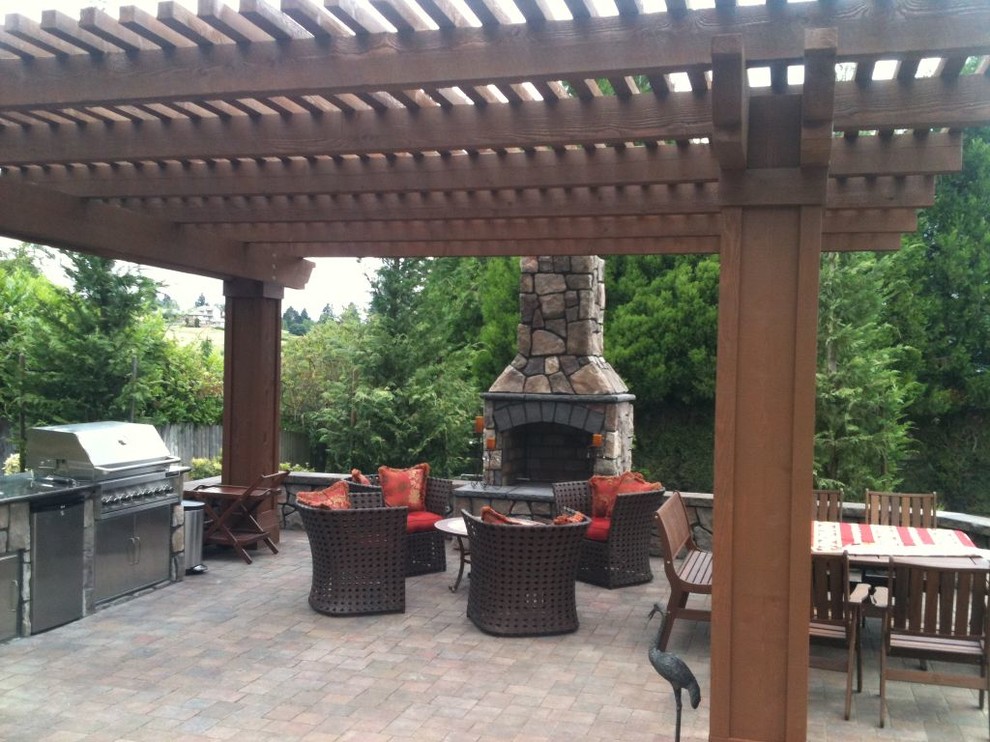 Diseño de patio clásico de tamaño medio en patio trasero con brasero, adoquines de hormigón y toldo