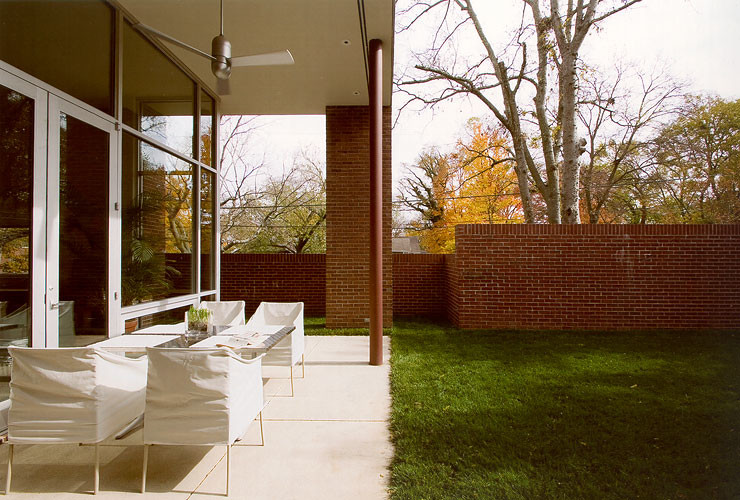 Immagine di un patio o portico moderno di medie dimensioni e dietro casa con cemento stampato e un tetto a sbalzo