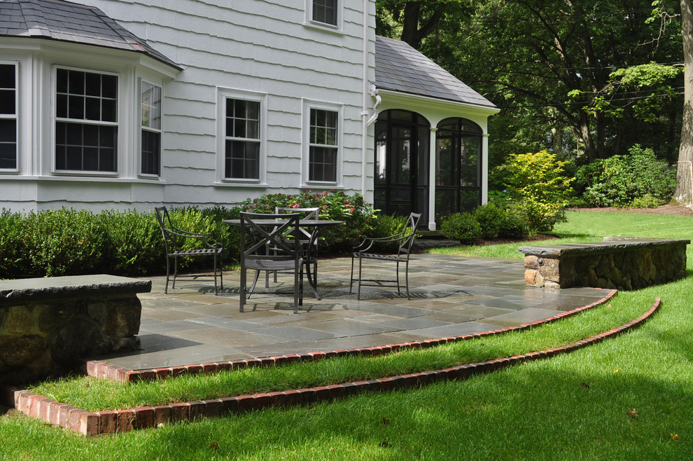 Foto di un grande patio o portico tradizionale dietro casa con pavimentazioni in pietra naturale