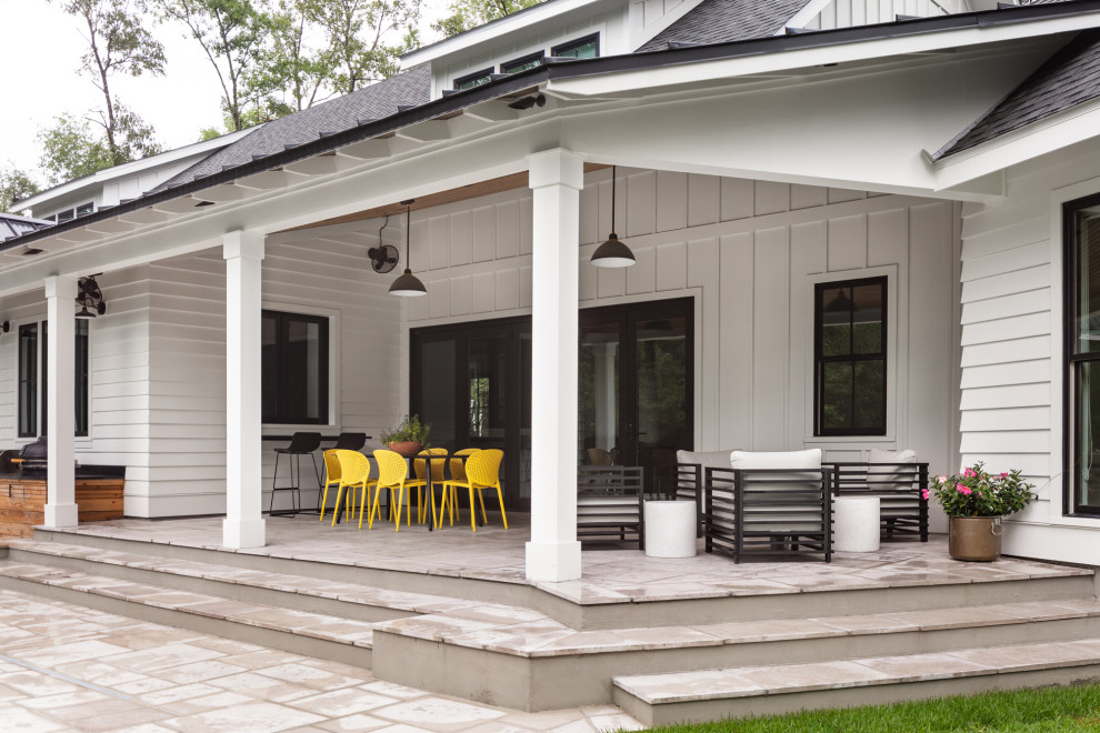 Exemple d'une grande terrasse arrière nature avec une cuisine d'été, des pavés en pierre naturelle et une extension de toiture.