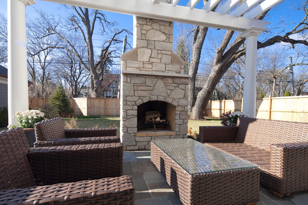 Mid-sized elegant side yard stone patio photo in Chicago with a fire pit and a pergola