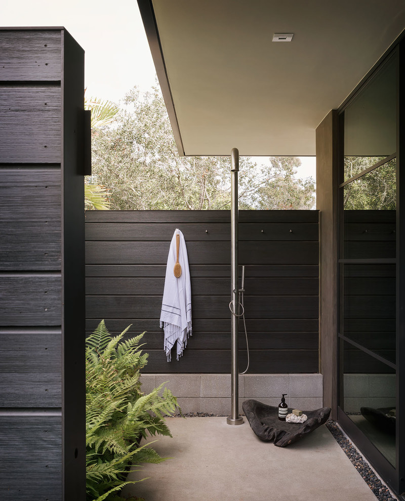 Photo of a retro patio in Orange County with an outdoor shower, concrete slabs and no cover.