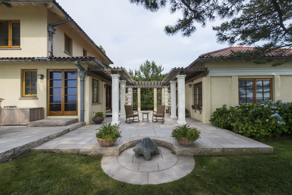 Esempio di un patio o portico mediterraneo di medie dimensioni e dietro casa con pavimentazioni in cemento e una pergola
