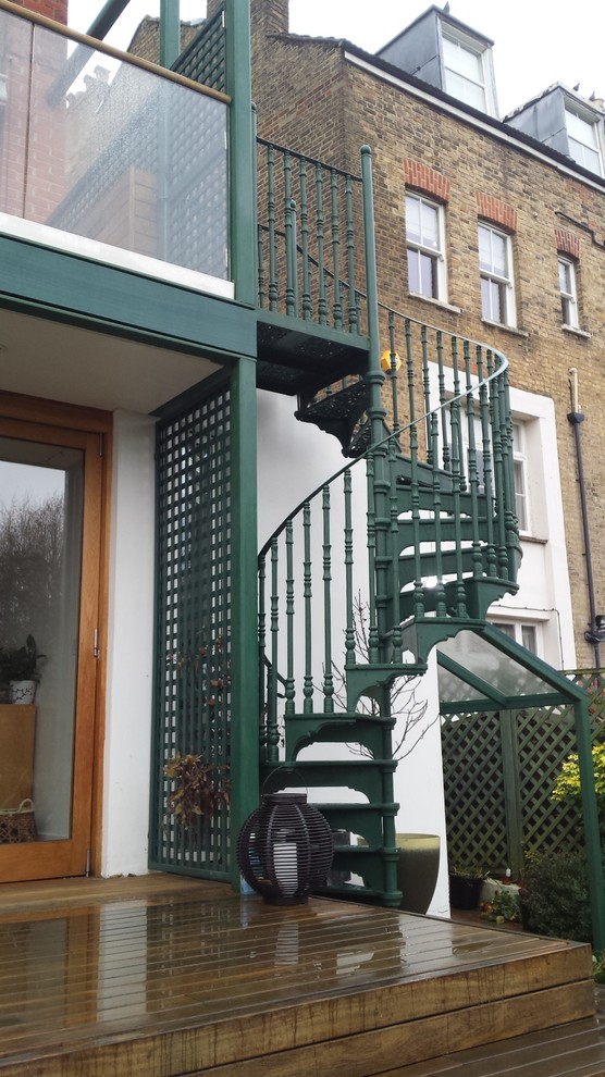 Immagine di un grande patio o portico eclettico dietro casa con un giardino in vaso e pedane