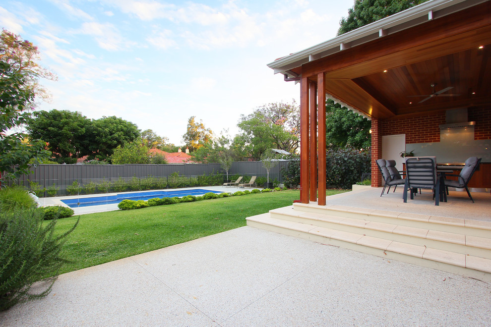 Aménagement d'une terrasse arrière classique de taille moyenne avec une cuisine d'été, du béton estampé et une extension de toiture.