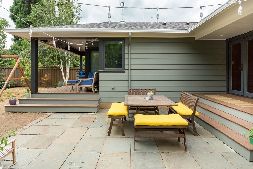 Photo of a midcentury back patio in Portland with natural stone paving and a roof extension.