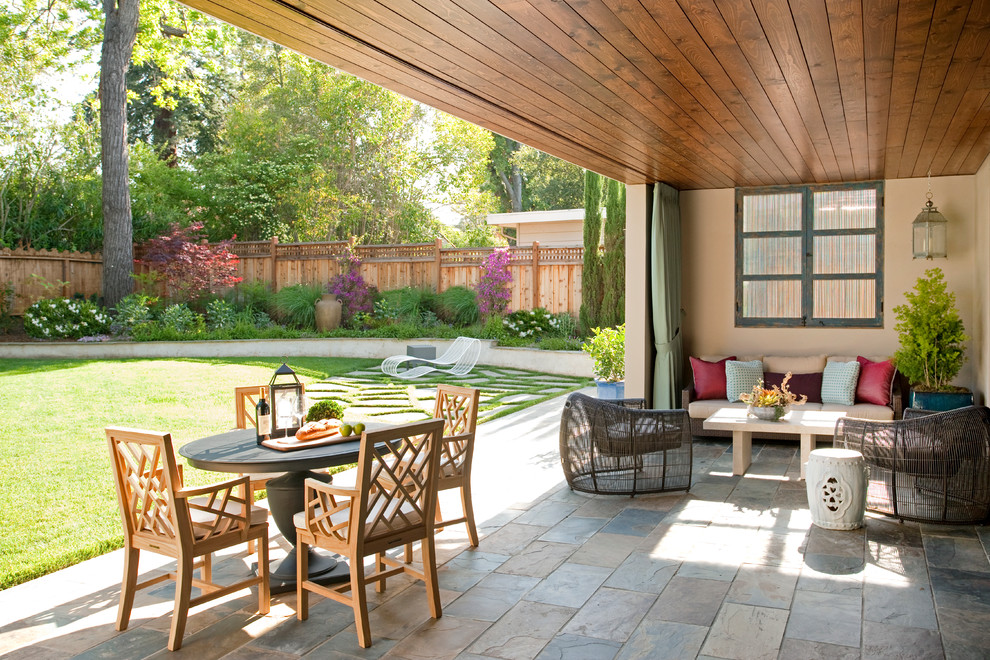 Immagine di un patio o portico design di medie dimensioni e dietro casa con un tetto a sbalzo e pavimentazioni in pietra naturale