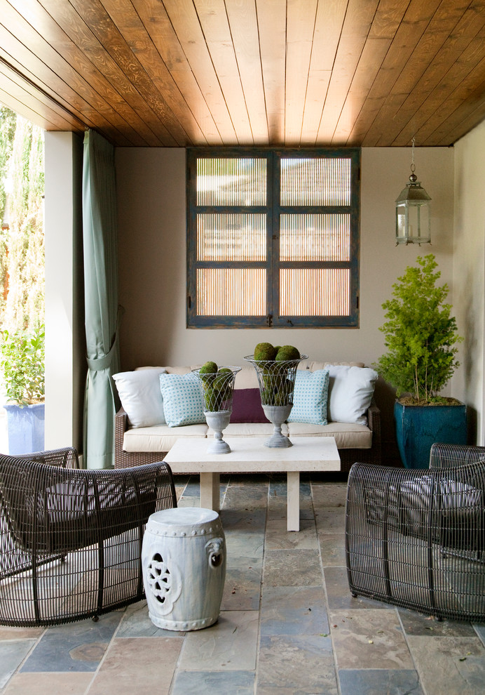 Foto di un patio o portico minimal di medie dimensioni e dietro casa con un tetto a sbalzo e pavimentazioni in pietra naturale