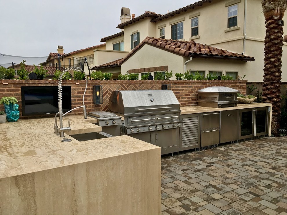 Inspiration for a huge contemporary backyard concrete paver patio kitchen remodel in San Diego with a pergola