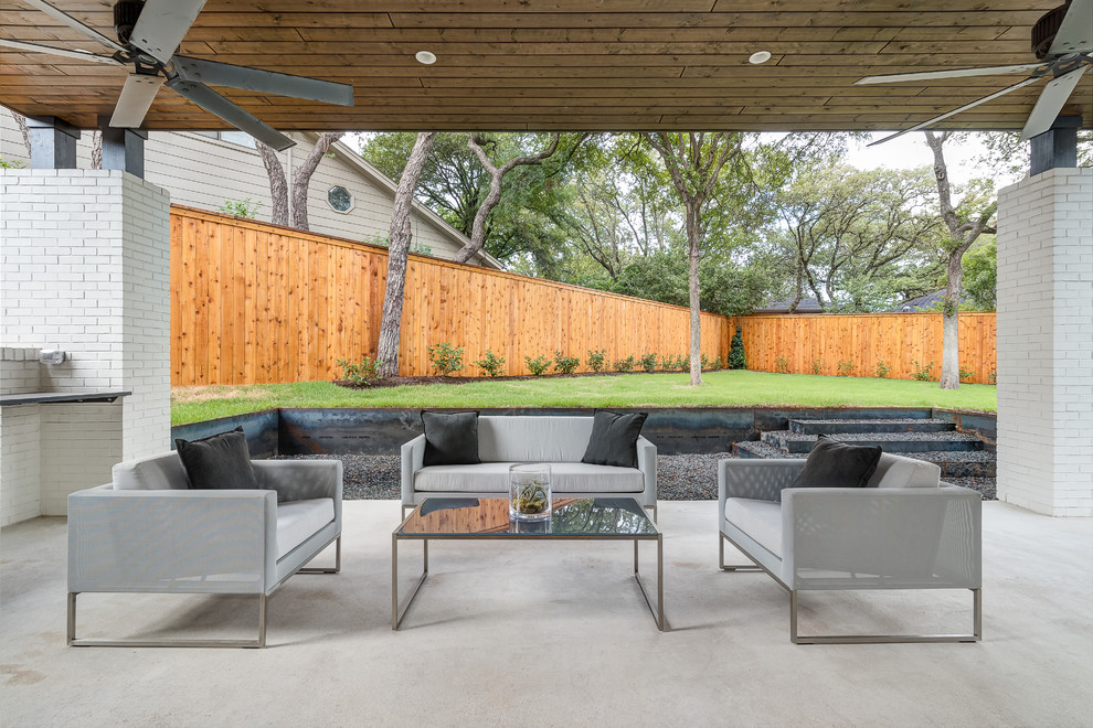 На фото: двор среднего размера на заднем дворе в современном стиле с покрытием из бетонных плит, навесом и летней кухней