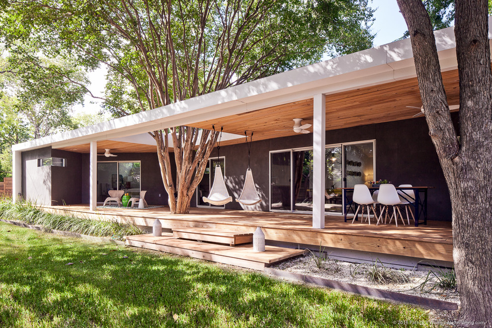 This is an example of a contemporary back patio in Austin with decking and a roof extension.