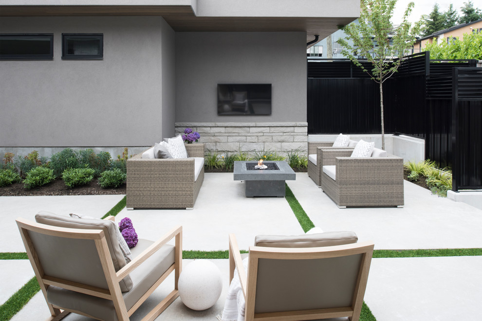 Patio - contemporary backyard concrete paver patio idea in Vancouver with a fire pit and a roof extension