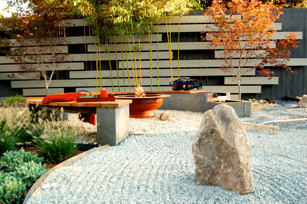 Imagen de patio de estilo zen de tamaño medio sin cubierta en patio trasero con brasero y gravilla