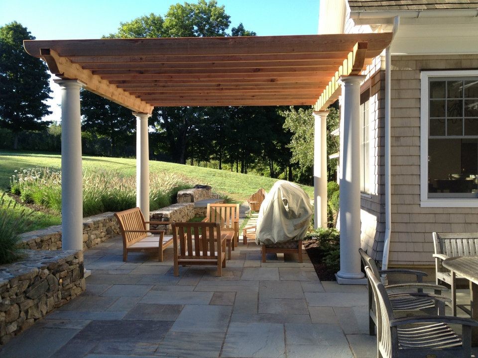 Foto di un patio o portico chic di medie dimensioni e dietro casa con pavimentazioni in pietra naturale e una pergola