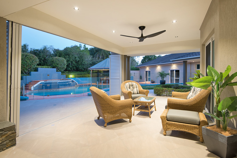 Photo of a medium sized contemporary back patio in Brisbane with natural stone paving and a roof extension.