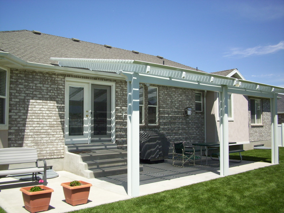 Idee per un patio o portico stile marinaro di medie dimensioni e dietro casa con lastre di cemento e una pergola