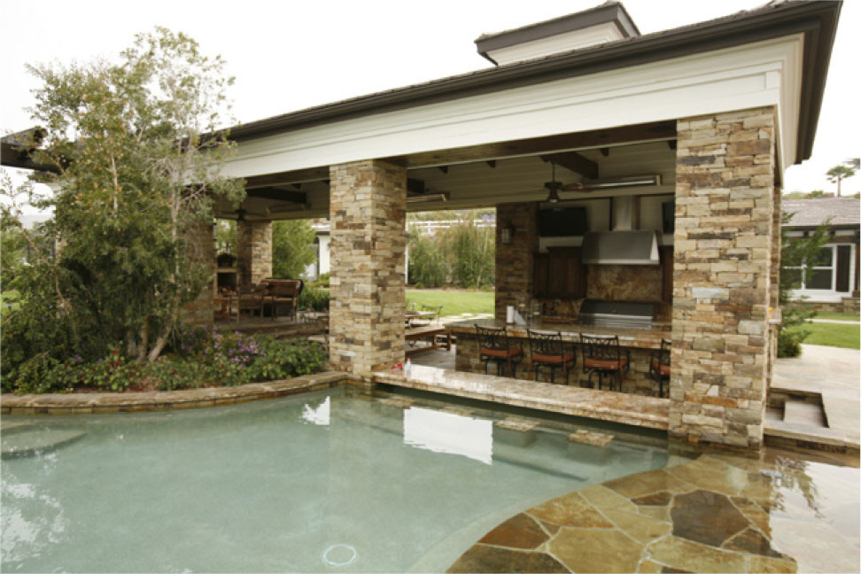 Photo of a large traditional back patio in Orange County with an outdoor kitchen, natural stone paving and a pergola.