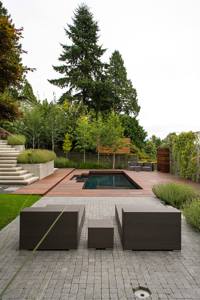 Imagen de patio contemporáneo de tamaño medio sin cubierta en patio trasero con adoquines de piedra natural