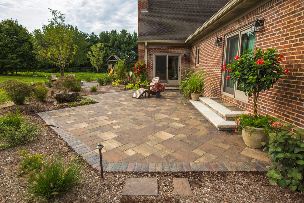 Photo of a medium sized rustic back patio in Indianapolis with a fire feature and concrete paving.