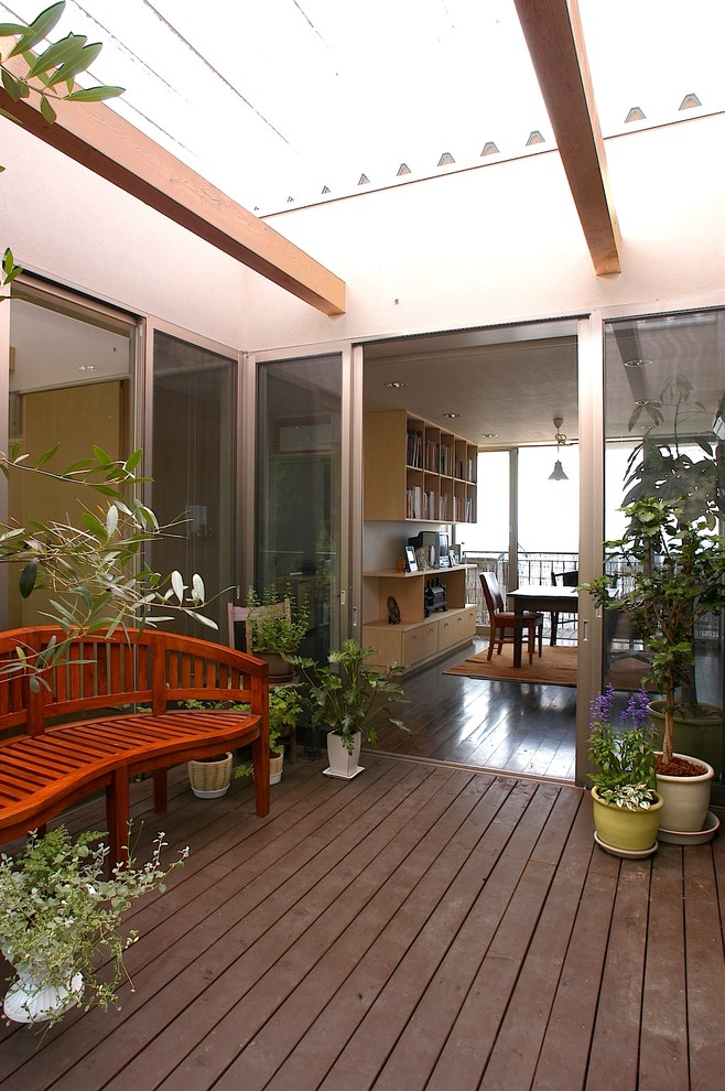 Cette photo montre une terrasse en bois moderne avec une cour.