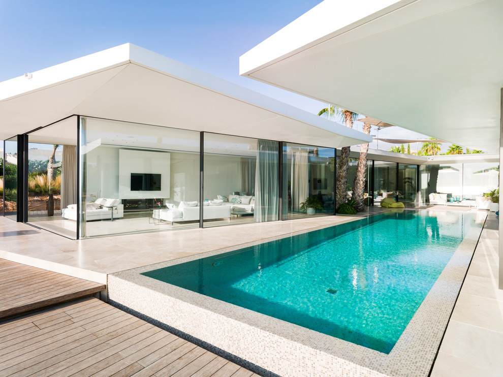 Cette photo montre une piscine moderne rectangle avec une cour et une terrasse en bois.