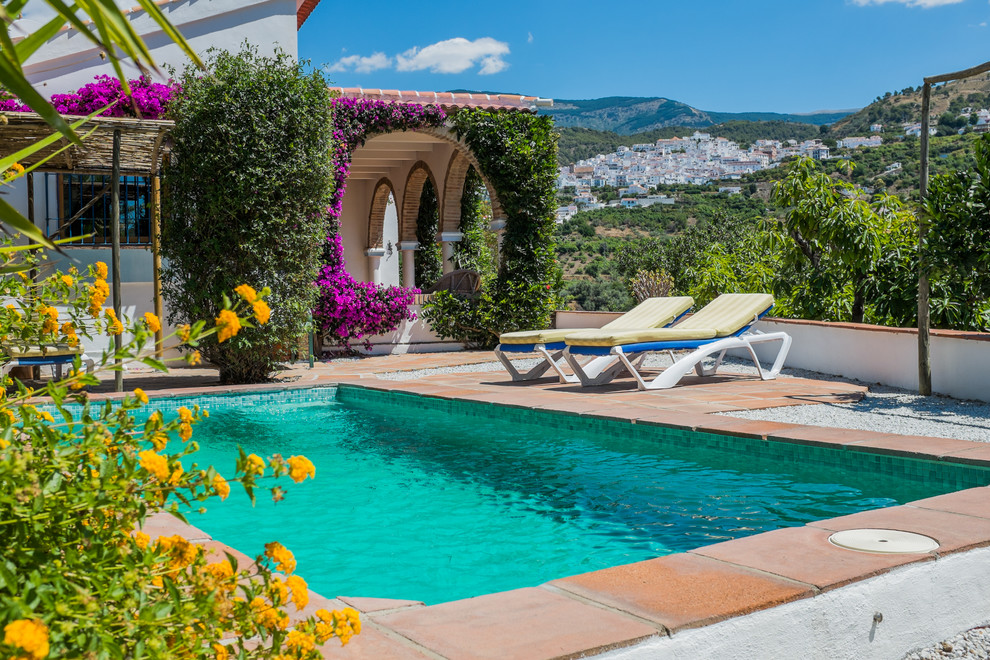 Esempio di una grande piscina monocorsia mediterranea rettangolare dietro casa con piastrelle