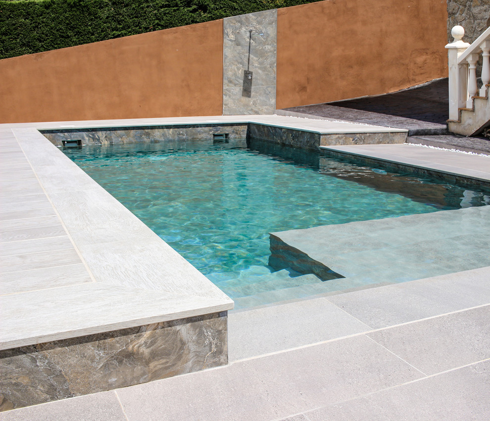 Exemple d'une piscine naturelle moderne de taille moyenne et sur mesure avec une cour et du carrelage.