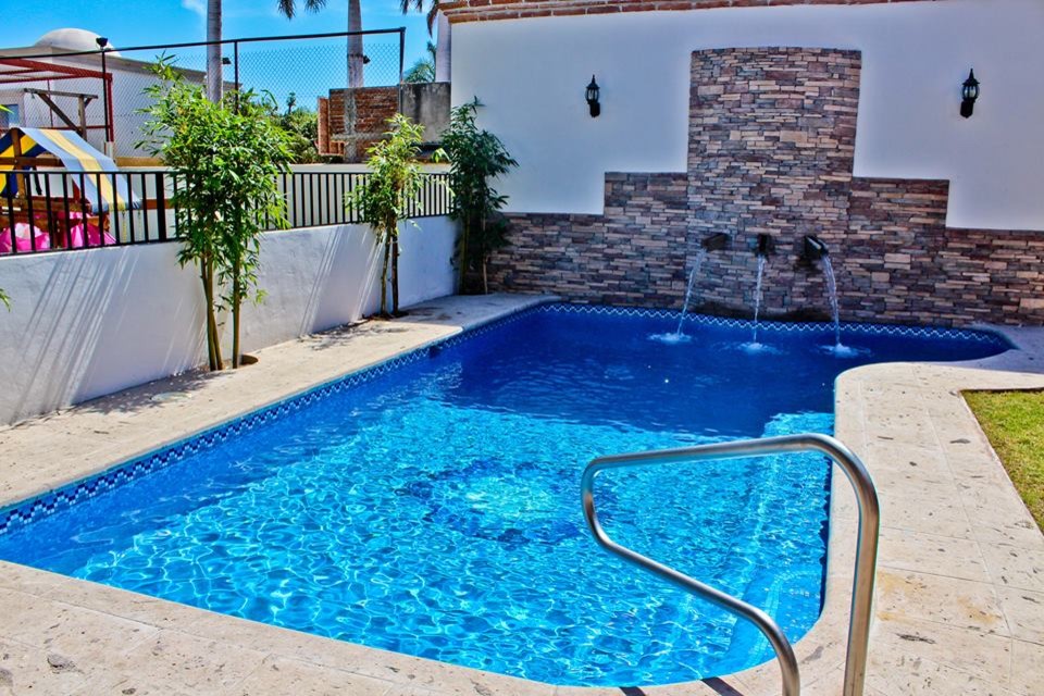 Example of a classic backyard stone and custom-shaped pool design in Mexico City