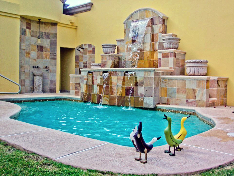 Foto di una piccola piscina chic personalizzata dietro casa con pavimentazioni in pietra naturale