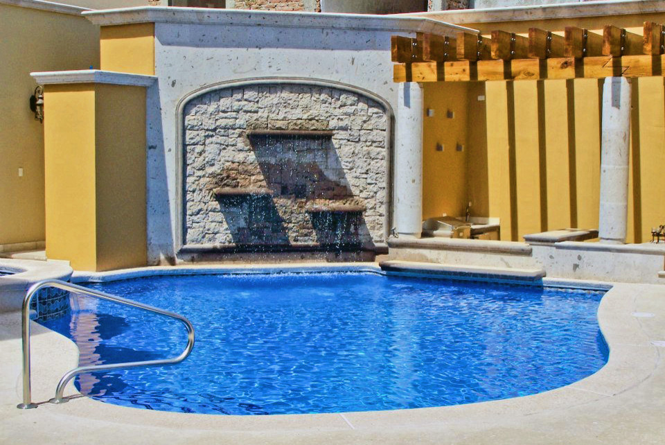 Imagen de piscina clásica grande a medida en patio con adoquines de piedra natural