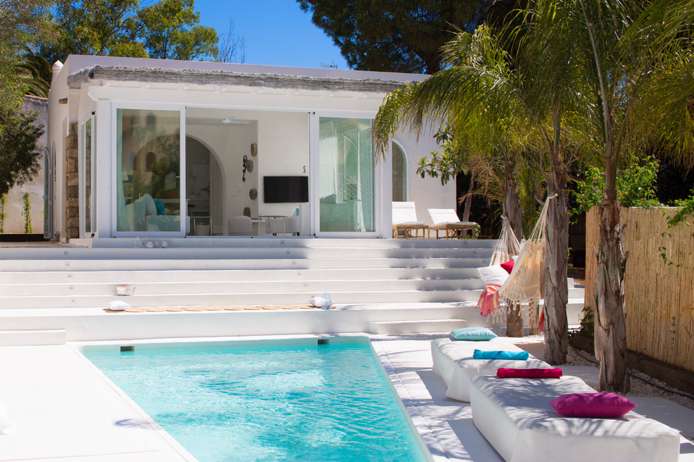 Imagen de casa de la piscina y piscina mediterránea de tamaño medio en patio delantero con losas de hormigón