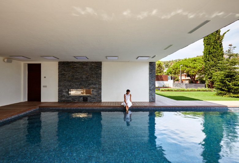 Inspiration pour une grande piscine avant design rectangle avec une terrasse en bois.