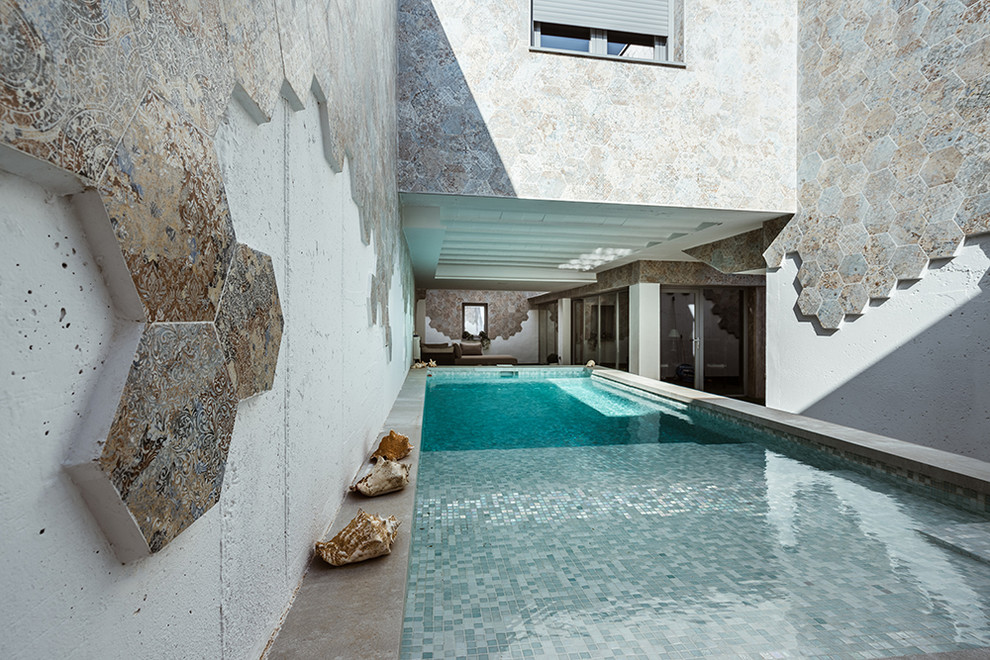 Foto di una piscina fuori terra scandinava rettangolare in cortile con una vasca idromassaggio e piastrelle