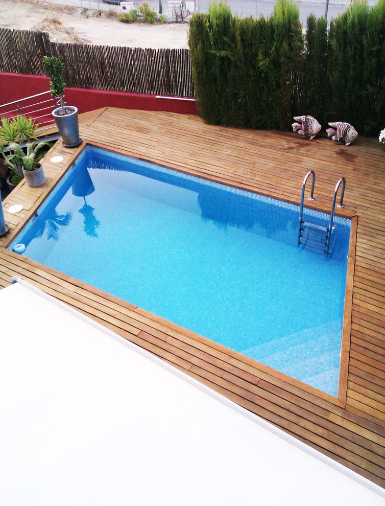 Photo of a medium sized classic front rectangular lengths swimming pool in Other with a pool house and decking.