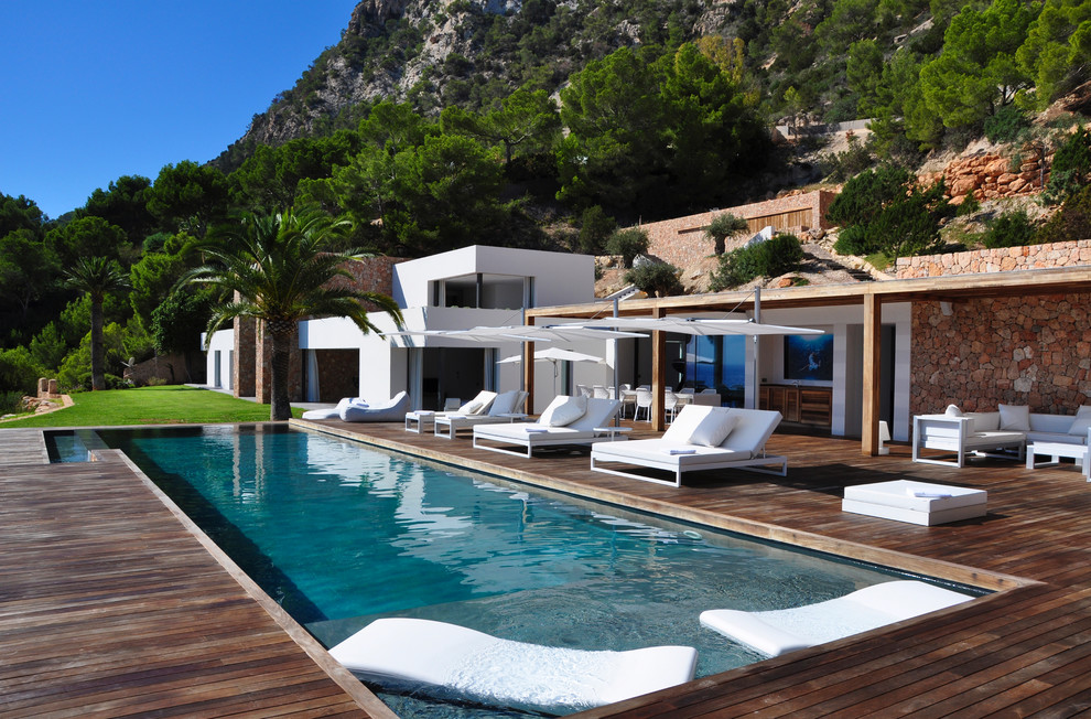 На фото: спортивный, прямоугольный бассейн среднего размера на внутреннем дворе в средиземноморском стиле с домиком у бассейна и настилом
