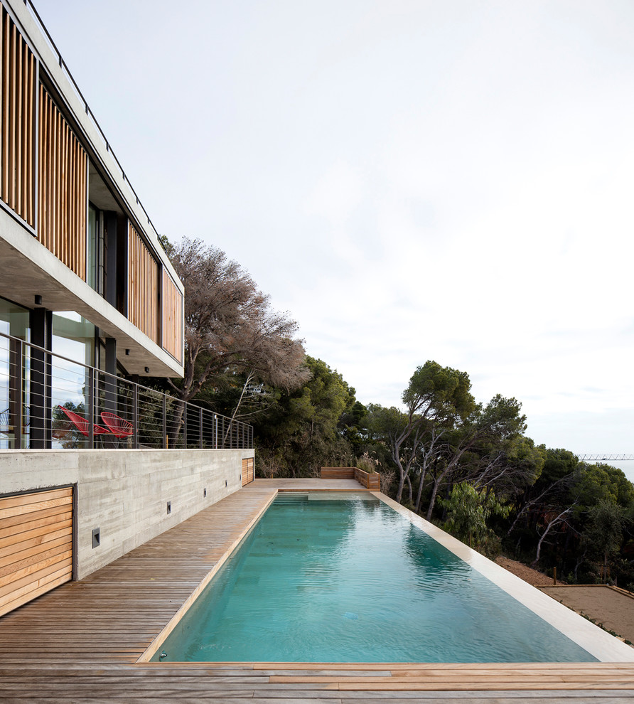 Imagen de casa de la piscina y piscina elevada moderna grande rectangular en patio delantero con entablado