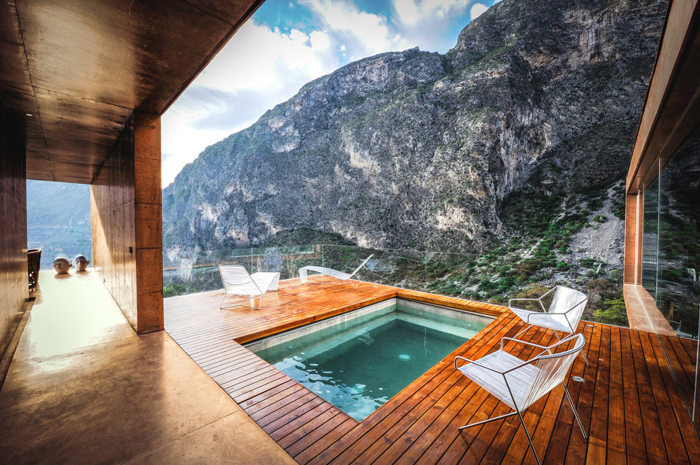 Idée de décoration pour une piscine minimaliste rectangle avec une terrasse en bois et un bain bouillonnant.