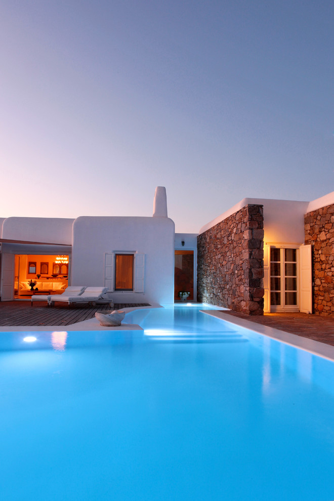 Свежая идея для дизайна: большой угловой бассейн на заднем дворе в средиземноморском стиле - отличное фото интерьера