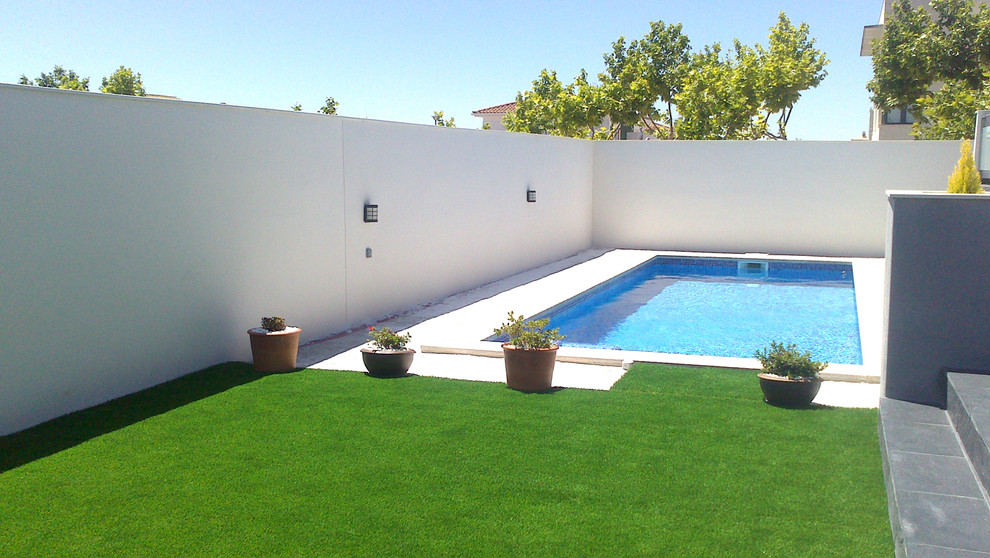 Esempio di una piscina monocorsia classica rettangolare di medie dimensioni e nel cortile laterale con una dépendance a bordo piscina