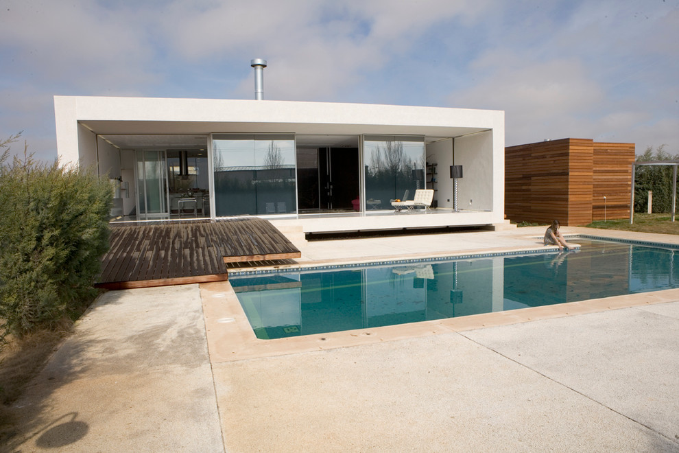 Foto de casa de la piscina y piscina alargada contemporánea de tamaño medio en forma de L en patio delantero