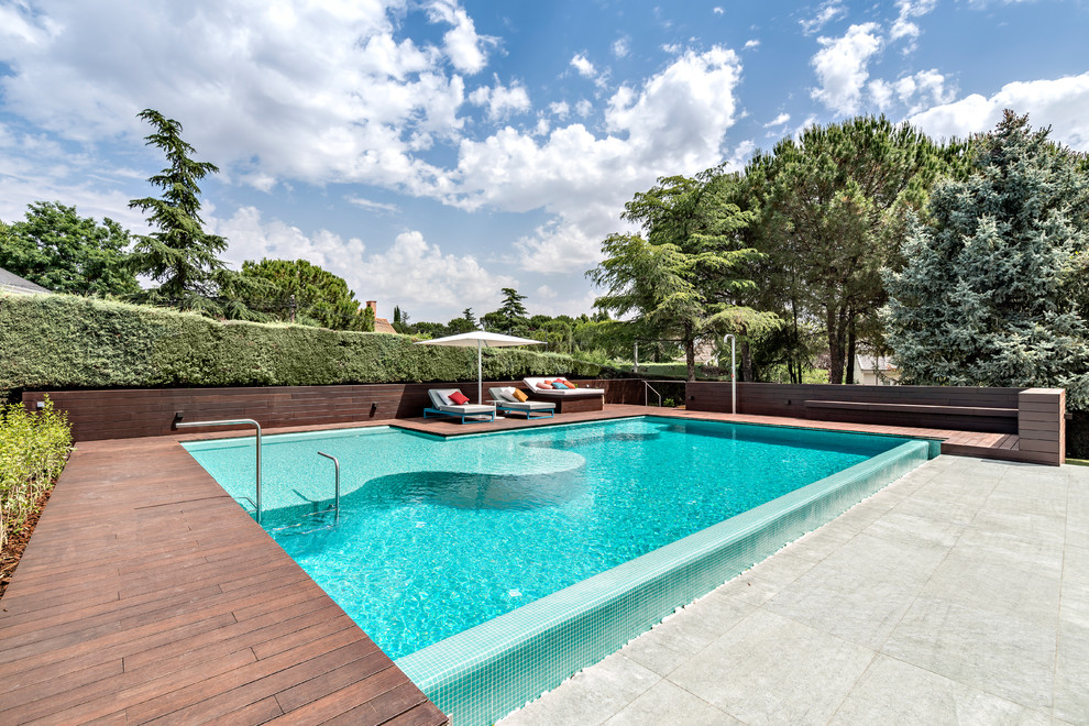 Imagen de piscina contemporánea de tamaño medio rectangular con entablado