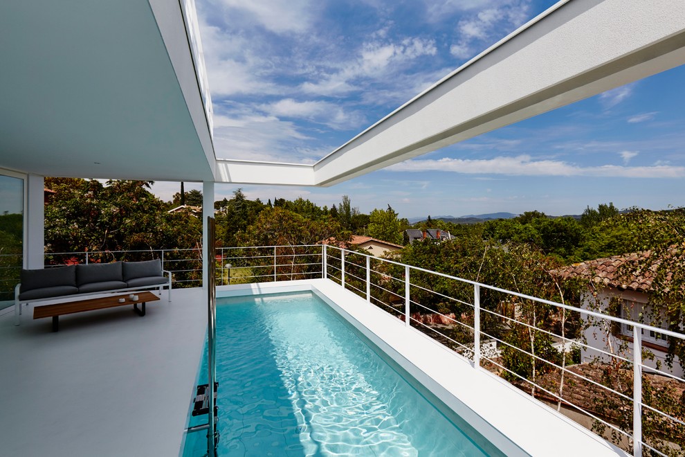 Esempio di una piscina monocorsia minimal rettangolare di medie dimensioni e sul tetto con una dépendance a bordo piscina
