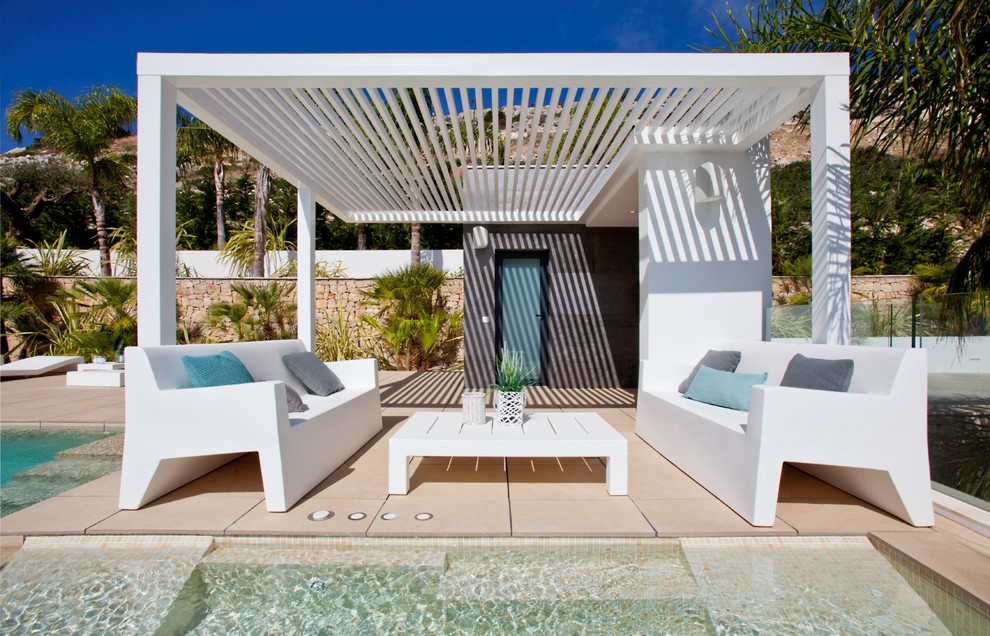Modelo de casa de la piscina y piscina infinita contemporánea grande a medida en patio trasero con suelo de baldosas