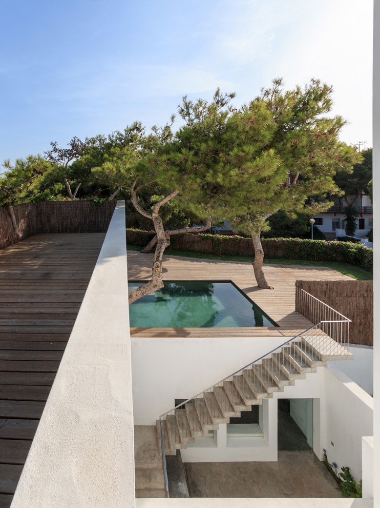 Exemple d'une petite piscine tendance rectangle avec une terrasse en bois.