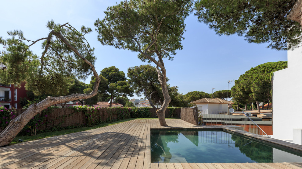 Inspiration pour une petite piscine design rectangle avec une terrasse en bois.